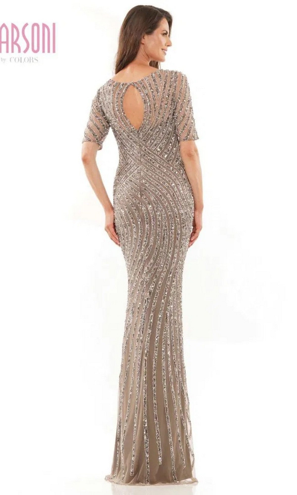 A woman faces away, wearing the Marsoni MV1209 long formal dress in taupe with silver bead embellishments and a keyhole back.